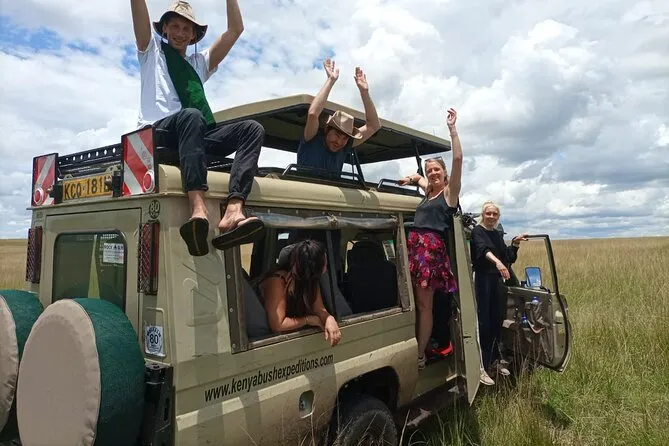 Safari game drive vehicle inside Nairobi National Park watching lions on open grassland with the Nairobi city skyline in the background — zoo in Nairobi Kenya